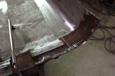 1948 Jeep Wrangler - A metal panel is being worked on, with visible grinding marks and chalk lines indicating cuts.
