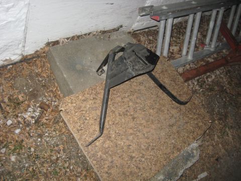 1988 Ford Bronco - A metal bracket is shown on a cork board, with a ladder in the background.