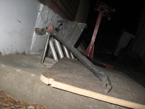 1988 Ford Bronco - A metal bracket and a sawhorse are visible in this dimly lit scene.