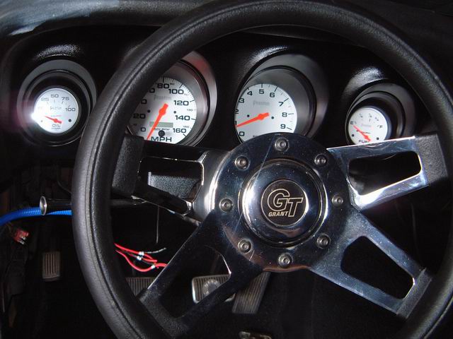 1970 Ford Mustang interior with Grant GT steering wheel and dashboard gauges showing oil pressure, MPH, RPM, and fuel level