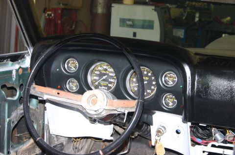 1970 Ford Mustang - The interior dashboard of a 1970 Ford Mustang shows a steering wheel and multiple gauges.