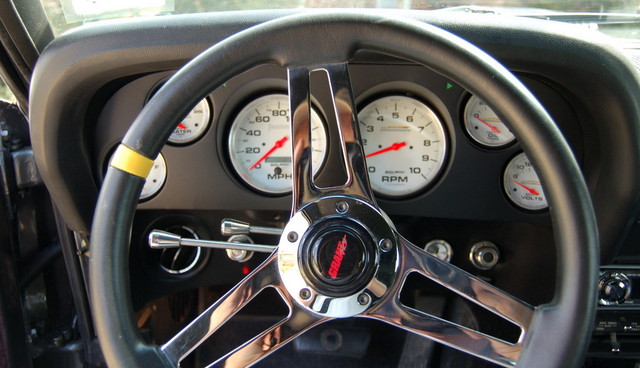 1970 Ford Mustang interior showing Grant steering wheel and white-faced gauges including speedometer, tachometer, and voltmeter