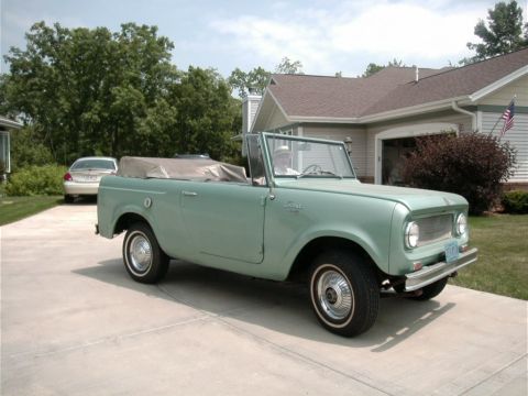1993 Ford Bronco - A light green convertible sits in a driveway in front of a house, with another car visible in the background.