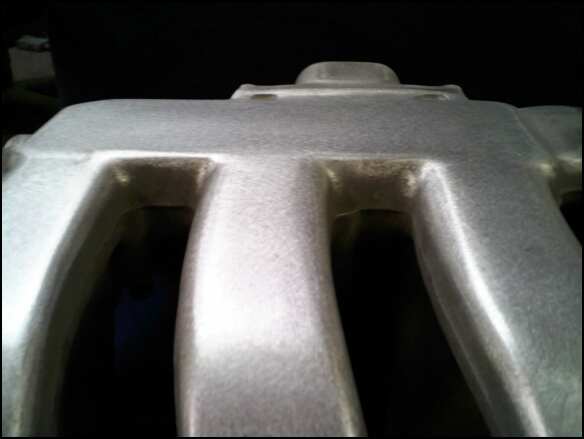 Close-up of a silver aluminum intake manifold with multiple runners
