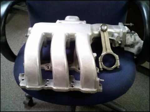 1994 Ford Probe - This is a close-up of an engine's intake manifold and a connecting rod.