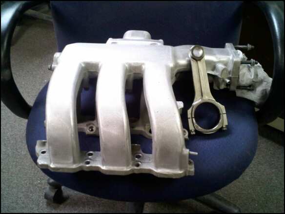 intake manifold and connecting rod on a chair