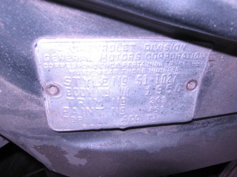 1986 Ford Bronco - Close-up of a Chevrolet Division General Motors Corporation VIN plate showing various identification codes.