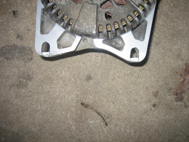 Close-up of an alternator part on a concrete surface