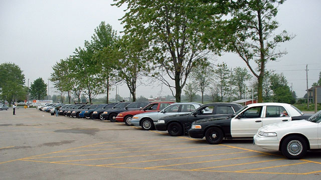 Side view of white and black police cars parked in a lot