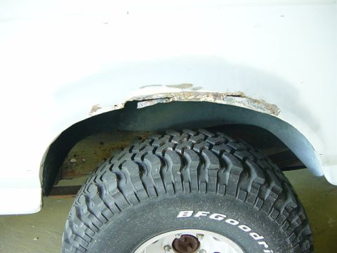 1993 Ford Bronco - Rusted wheel well shows significant corrosion. Tire branding is visible.