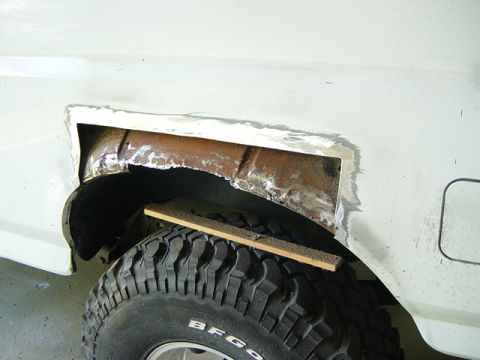 1993 Ford Bronco - Repairing rust damage on the wheel well of a vehicle. The tire is visible with 'BFG' text.