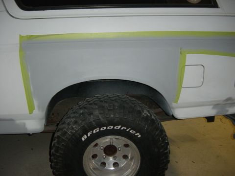 1993 Ford Bronco - Body panel masked with tape and primer applied, ready for paintwork on a Ford Bronco.