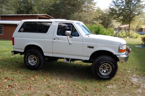 1993 Ford Bronco - This 1993 Ford Bronco is shown in a three-quarter front view, highlighting its white exterior and aftermarket wheels.