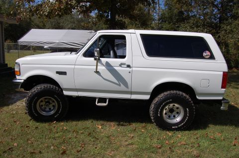 1993 Ford Bronco - This white Ford Bronco, likely a 1992 model, is shown from the side with off-road tires and wheels.