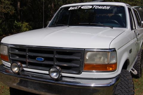 1993 Ford Bronco - This Ford pickup truck features a prominent grille and auxiliary lights on the bumper.