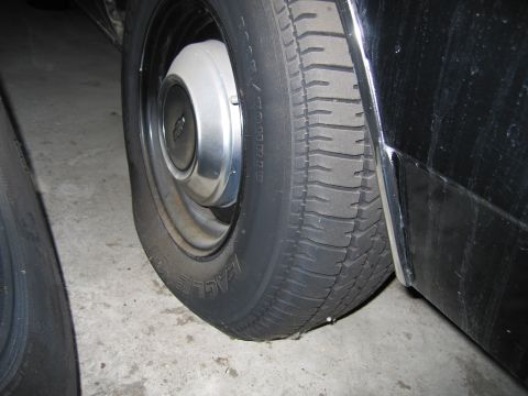 1991 Ford LTD Crown Victoria - Photograph of a steel wheel, hubcap, and tire on a car, not a technical document.