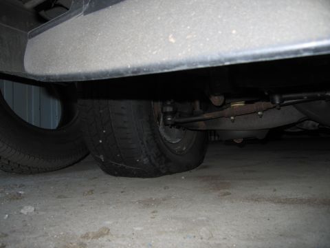 1991 Ford LTD Crown Victoria - Photograph of a vehicle undercarriage showing front suspension and tires, not a technical document.