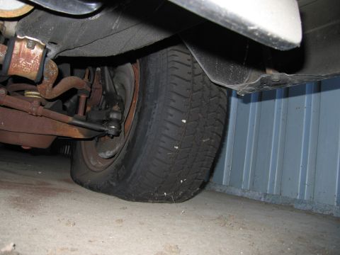 1991 Ford LTD Crown Victoria - Photograph of a vehicle front wheel and suspension components from below, not a technical document.