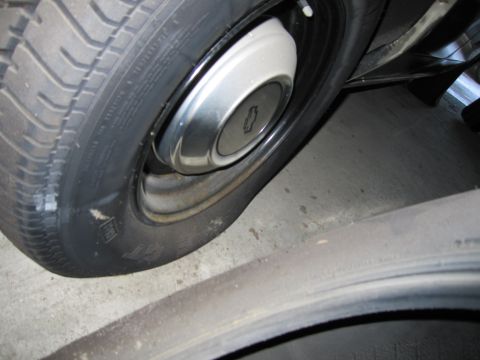 1991 Ford LTD Crown Victoria - Photograph of a wheel with Chevrolet hubcap and tire, not a technical document.