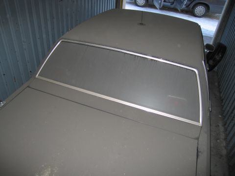 1991 Ford LTD Crown Victoria - Photograph of the dusty roof and rear window of a stored sedan, not a technical document.