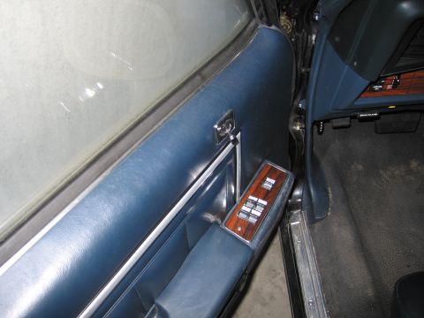 1991 Ford LTD Crown Victoria - Photograph of a blue vehicle door panel with power-window switch trim, not a technical document.