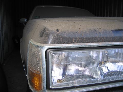 1991 Ford LTD Crown Victoria - Photograph of the front headlight and fender of a dusty Chevrolet, not a technical document.