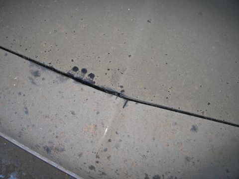 1991 Ford LTD Crown Victoria - Photograph of a dusty vehicle hood and panel gap, not a technical document.