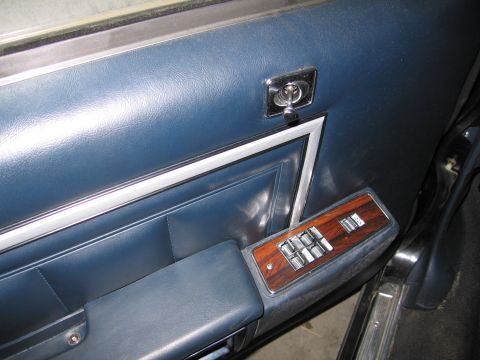 1991 Ford LTD Crown Victoria - Photograph of a blue vehicle door panel and power-window switch trim, not a technical document.