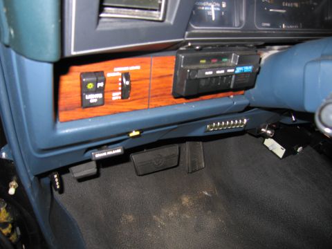 1991 Ford LTD Crown Victoria - Photo of a vehicle's under-dash switches and pedal area, not a document.