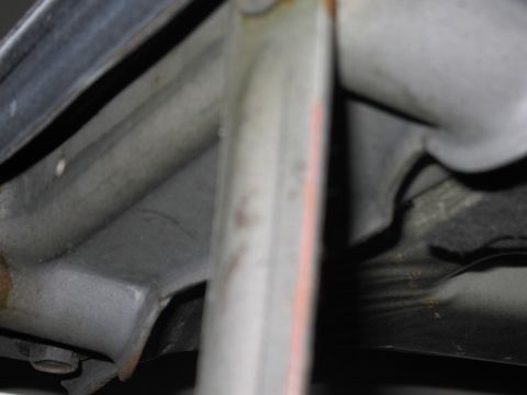 1991 Ford LTD Crown Victoria - Blurry photo of vehicle sheet-metal/undercarriage parts, not a document.