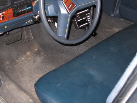 1991 Ford LTD Crown Victoria - Photo of a vehicle interior footwell and bench seat, not a document.