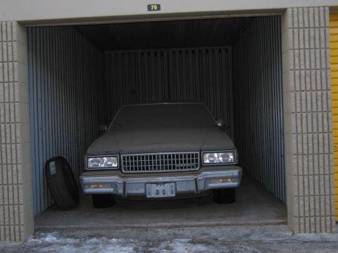 1991 Ford LTD Crown Victoria - Photo of a sedan parked in a storage unit, not a document.