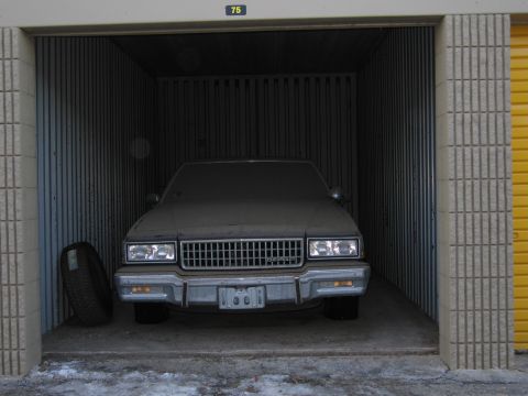 1991 Ford LTD Crown Victoria - Photo of a sedan in a storage unit, not a document.