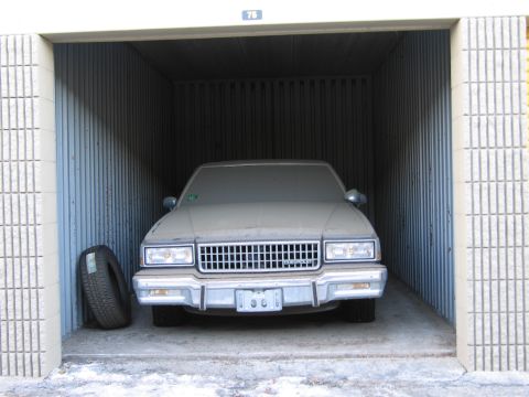 1991 Ford LTD Crown Victoria - Photo of a sedan in a storage unit, not a document.
