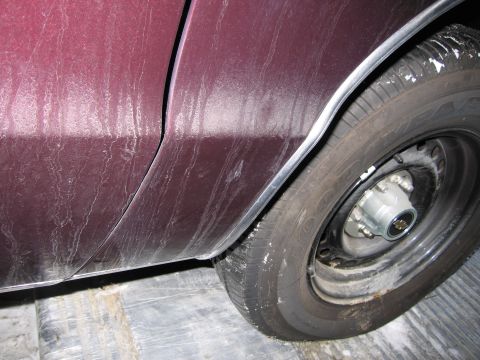 1991 Ford LTD Crown Victoria - Close-up photo of a maroon car rear quarter panel, rocker trim, and wheel.