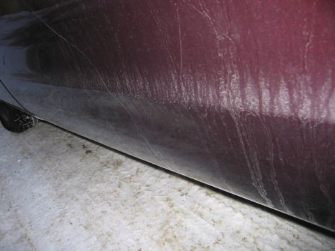 1991 Ford LTD Crown Victoria - Photograph of a maroon vehicle's lower door and rocker panel, not a technical document.