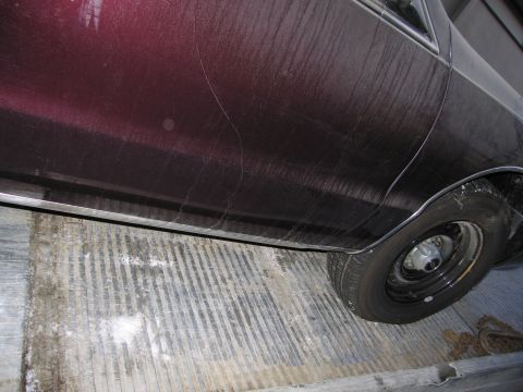1991 Ford LTD Crown Victoria - Photograph of a vehicle's lower body side and rear wheel, not a technical document.