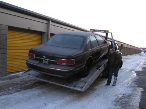 1991 Ford LTD Crown Victoria - Photograph of a Chevrolet sedan on a flatbed tow truck, not a technical document.