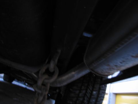 1991 Ford LTD Crown Victoria - Photograph of a vehicle undercarriage with exhaust and chain, not a technical document.