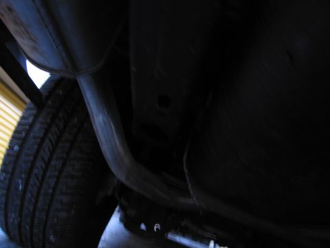 1991 Ford LTD Crown Victoria - Photograph of a vehicle undercarriage frame and exhaust, not a technical document.