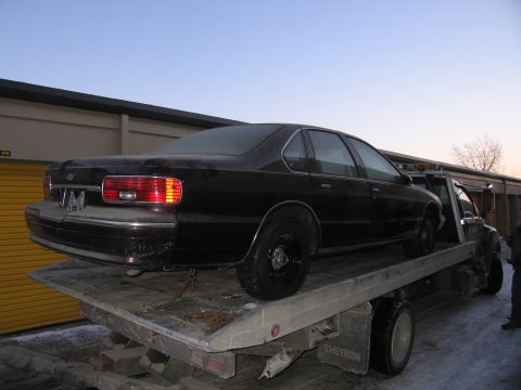 1991 Ford LTD Crown Victoria - Photograph of a Chevrolet Caprice on a flatbed tow truck, not a technical document.