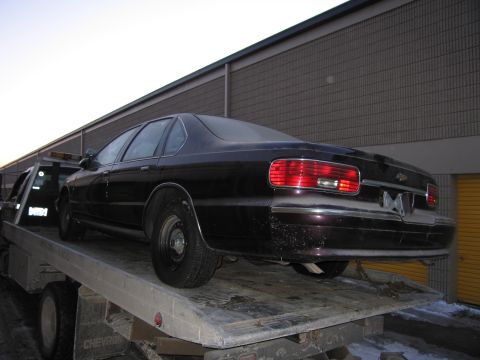 1991 Ford LTD Crown Victoria - Photograph of a Chevrolet sedan on a flatbed tow truck, not a technical document.