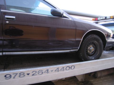 1991 Ford LTD Crown Victoria - Photograph of a car's door and front wheel on a flatbed, not a technical document.