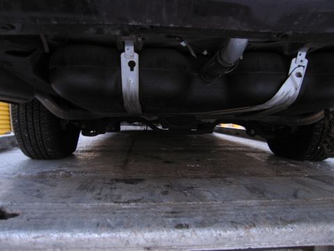 1991 Ford LTD Crown Victoria - Photograph of a vehicle undercarriage with fuel tank and exhaust, not a technical document.