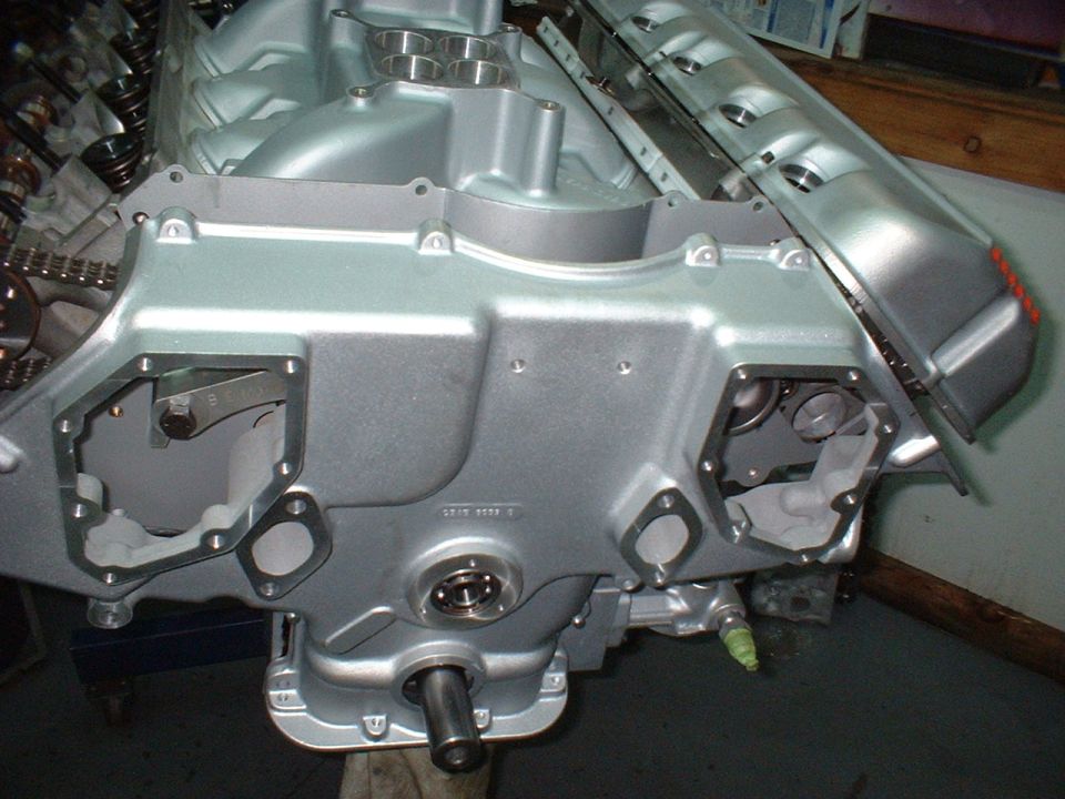 Silver V8 engine block with timing chain and valve springs visible.