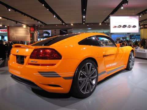 1996 Ford Probe - The rear passenger side of a bright orange electric concept coupe is displayed at an auto show. The car features a sleek design with distin…