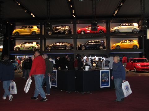 1996 Ford Probe - A display of cars at an auto show features several vehicles in cubbies, with a red car visible in the foreground.