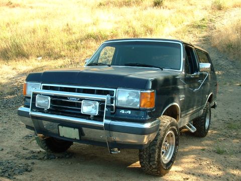 1991 Ford Bronco - This Ford Bronco is equipped with auxiliary lights and 4x4 badging, suggesting it's ready for off-road adventures.