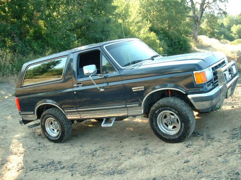 1991 Ford Bronco - This Ford Bronco is shown from a three-quarter front angle on a gravelly surface.