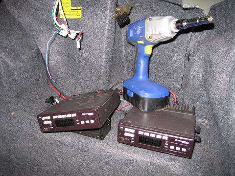 1991 Ford LTD Crown Victoria - Photograph of radio/control-head equipment and a power tool in a vehicle trunk, not a technical document.
